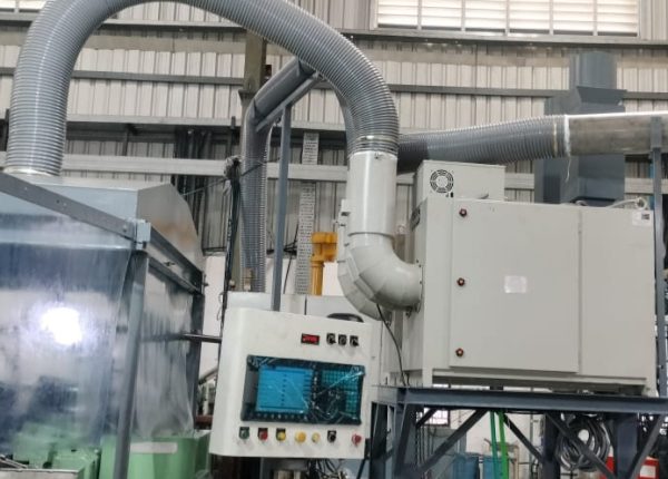 Fumekiller mounted on a pipe stand being used with a partial enclosure for extraction of mist generated during centerless grinding application.