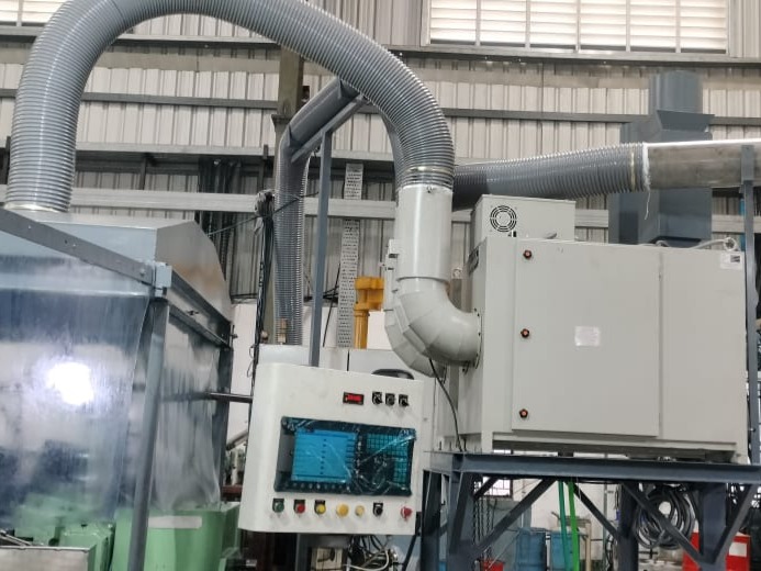 Fumekiller mounted on a pipe stand being used with a partial enclosure for extraction of mist generated during centerless grinding application.